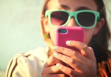 Young girl texting at the beach